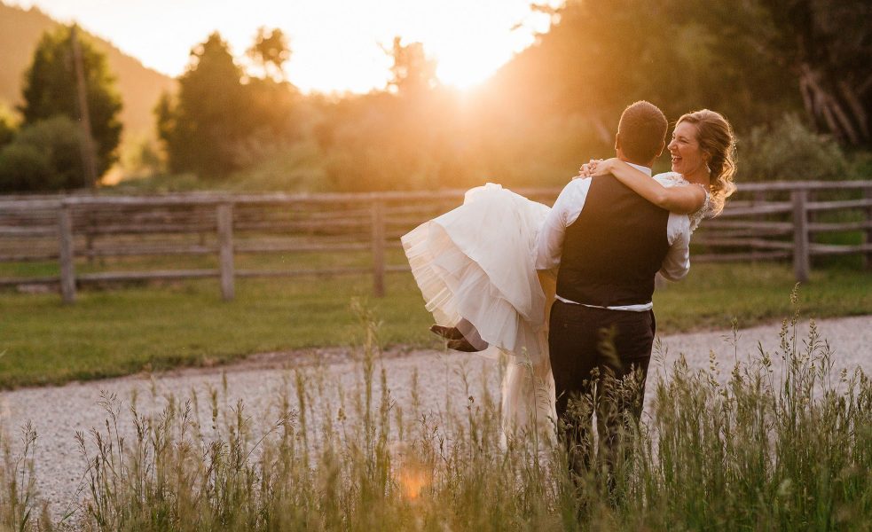 A groom carries his bride at sunset at Moose Creek Ranch photographed by Washington elopement photographer Amy Galbraith