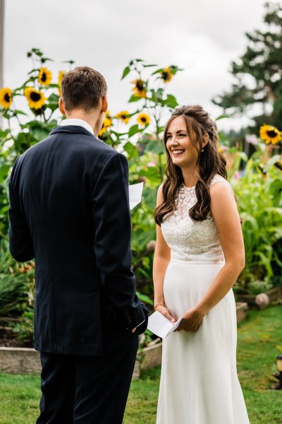 A bride listens to her groom say his vows in a sunflower garden on Camano Island