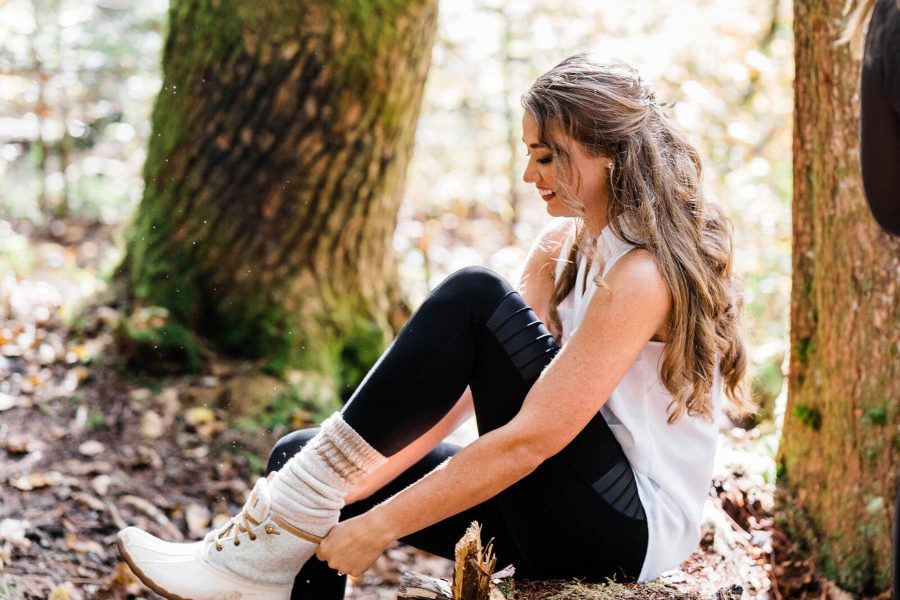 A bride puts on white hiking boots for her backcountry elopement in the Washington Cascades