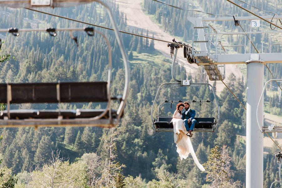 A couple rides a chairlift after their mountaintop elopement in Jackson Hole photographed by Washington elopement photographer Amy Galbraith