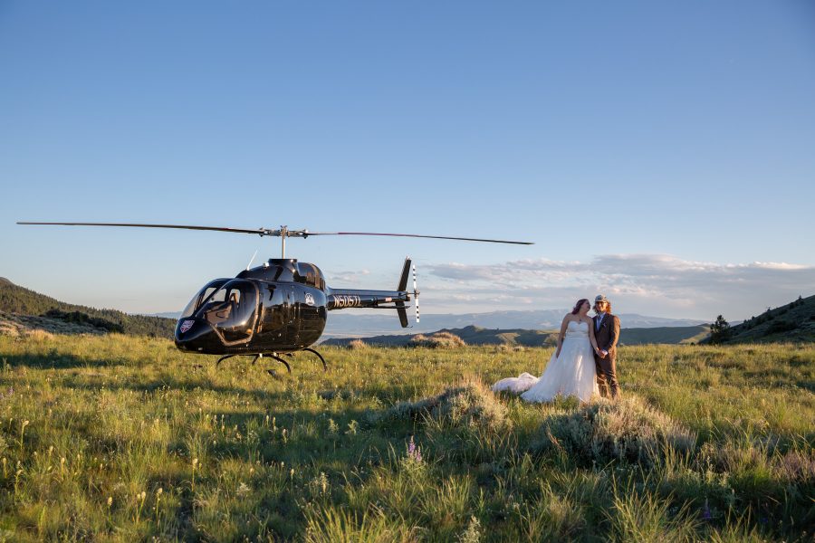 Helicopter landing in a field during an Alaska elopement experience