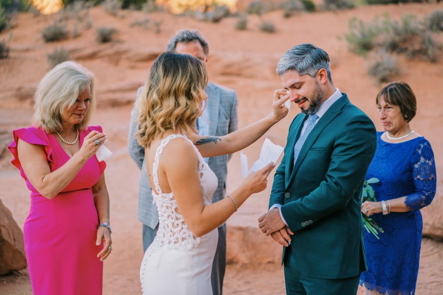 A groom tears up during elopement vows in a national park.