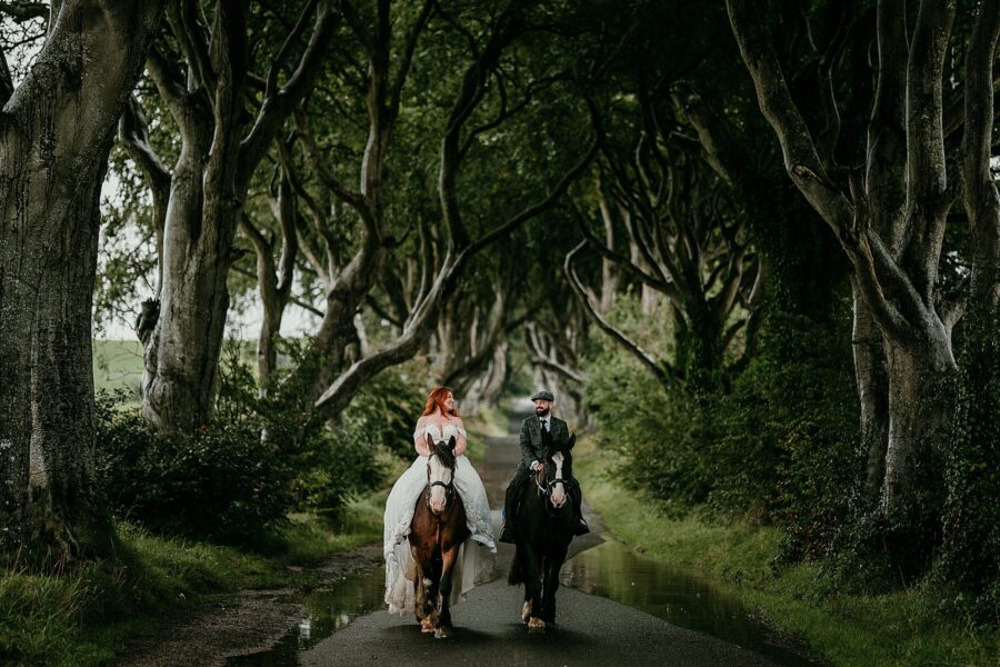 Bride & Groom horseback riding during their elopement at the dark Hedges in Northern Ireland.