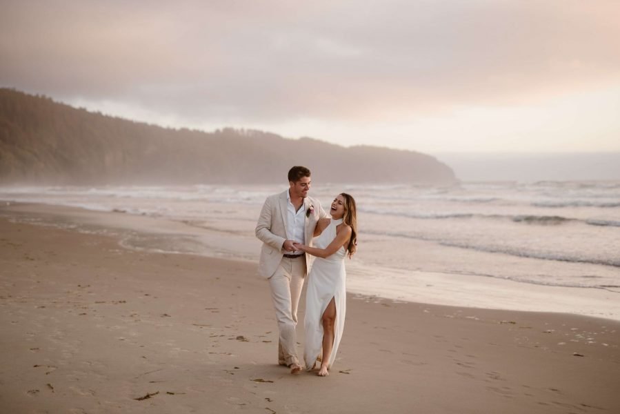 A man and woman embrace on the beach on the Oregon coast.