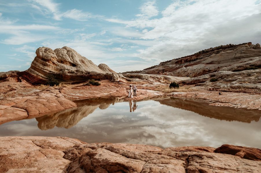 Landscape with tiny couple and their dogs reflected in mars like location in Arizona