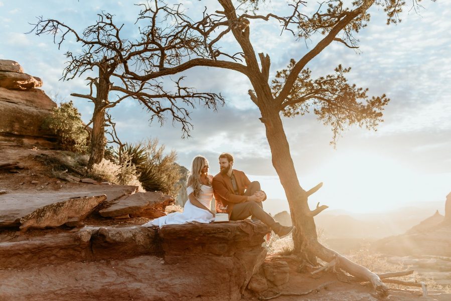 couple enjoying their mini wedding cake during sunset at their elopement in Sedona