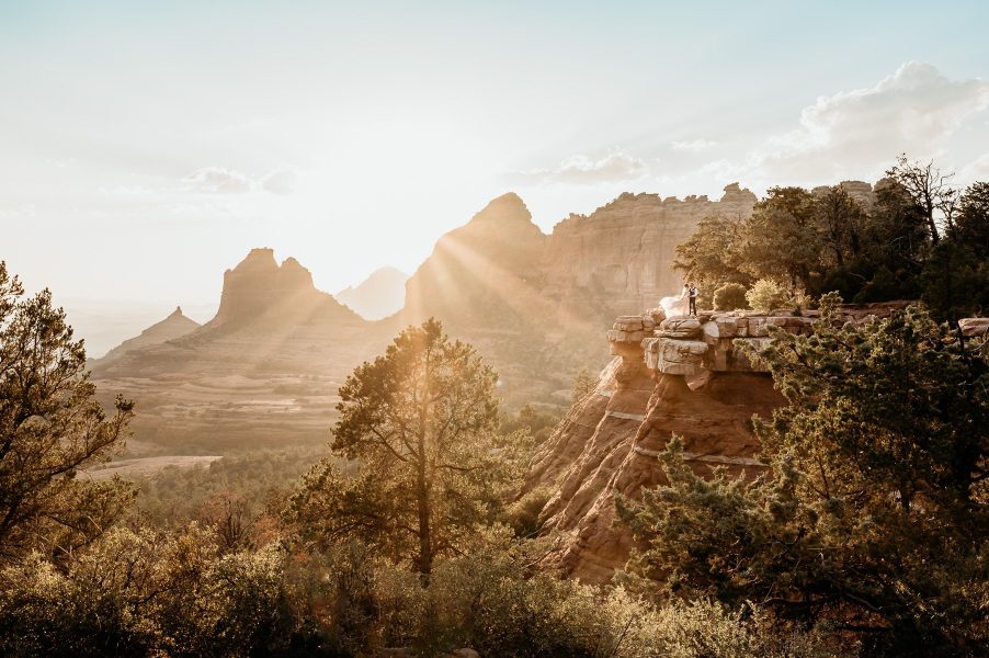 Fairytale sunset with elopement couple in the distance during sunset in Sedona