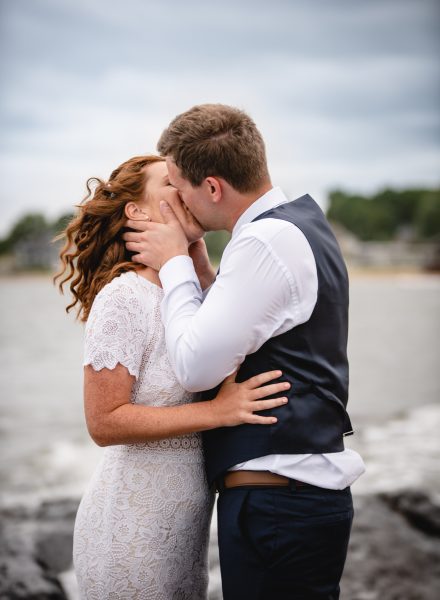 elopement couple kissing on rocky shore