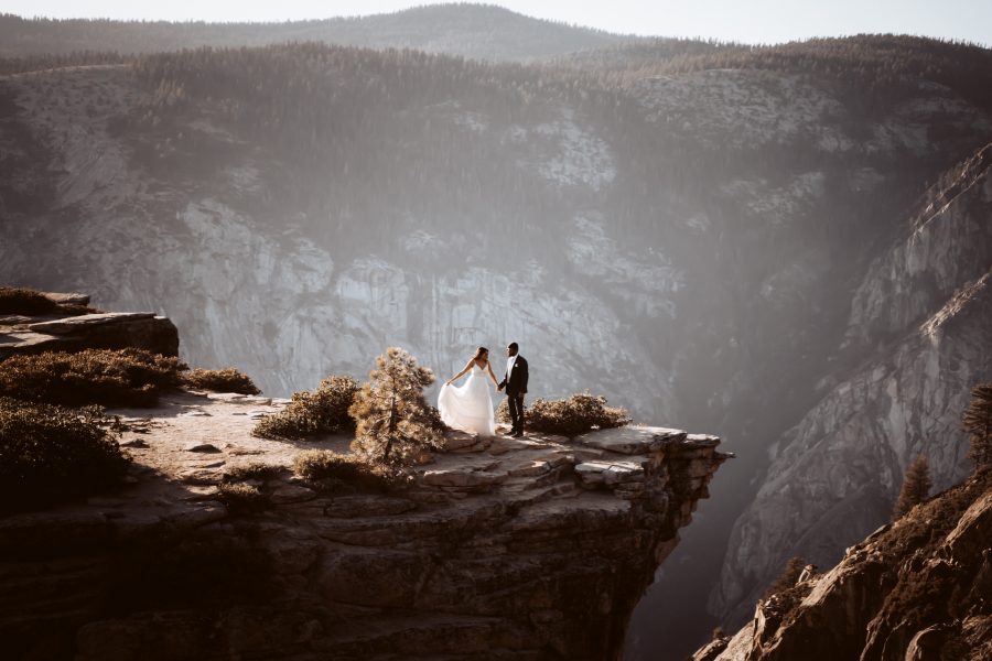 A wedding couple dancing at the edge of the rocks overlooking Yosemite Valley for their Sunset Yosemite Elopement