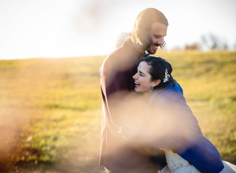 couple hugging and laughing in a field during their elopement photos