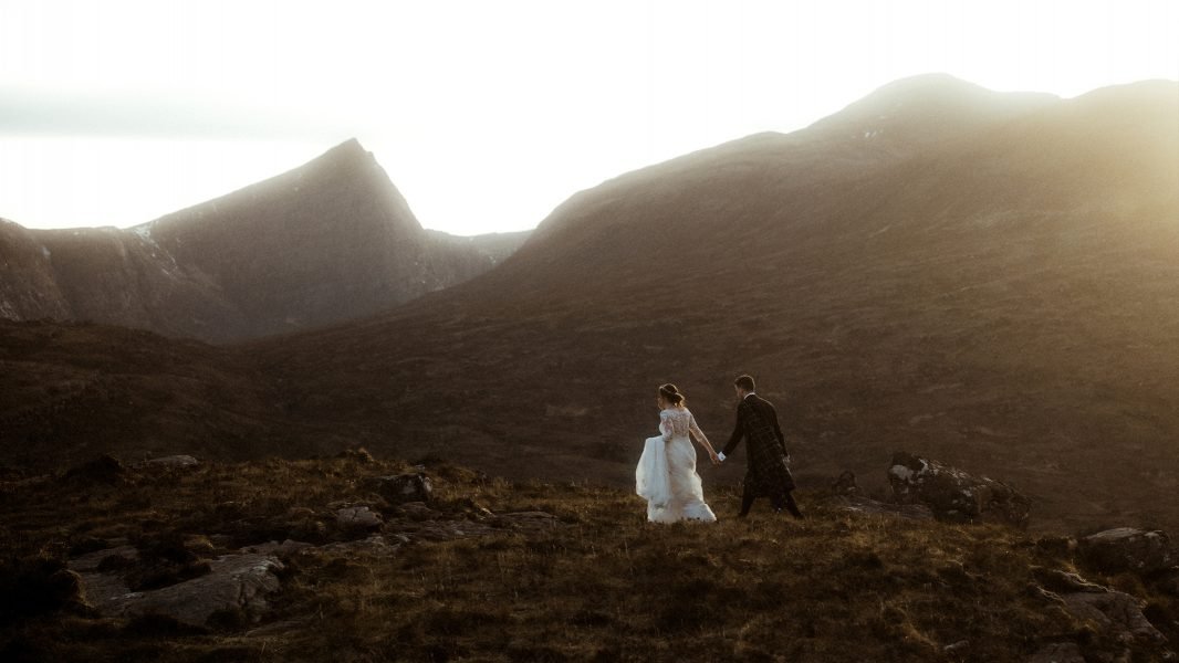 hiking elopement in scotland with couple in the mountains at sunset