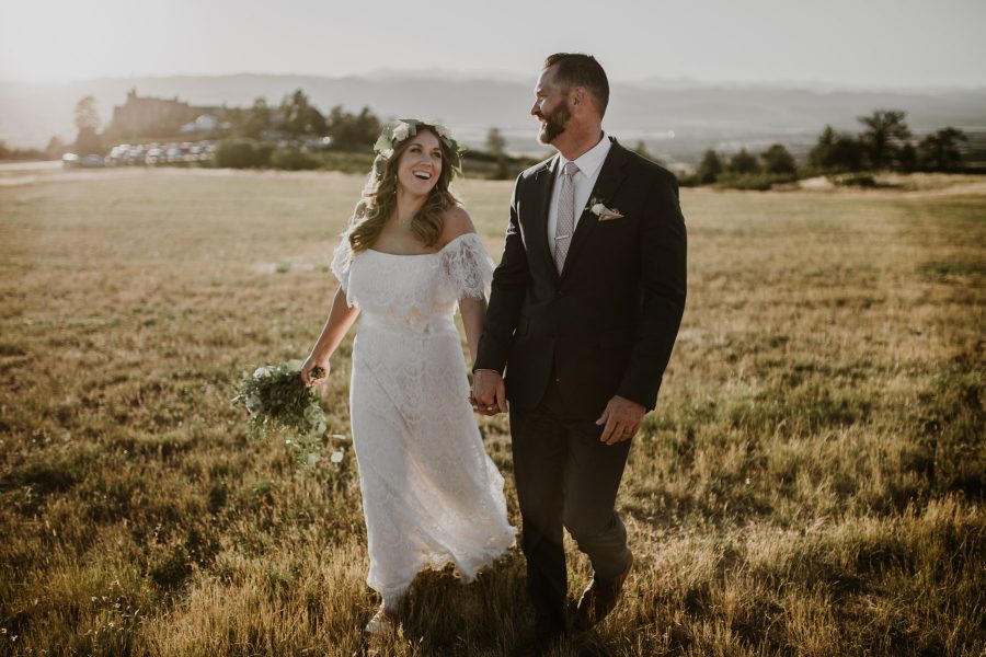 couple in wedding attire holding hands and walking