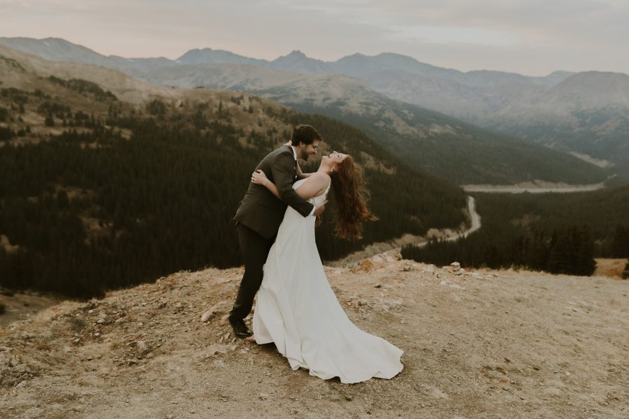 couple embracing and laughing on top of a mountain in Colorado