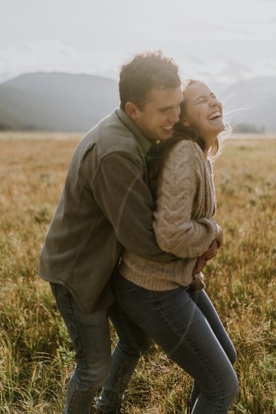 couple embracing and laughing in a valley in the mountains