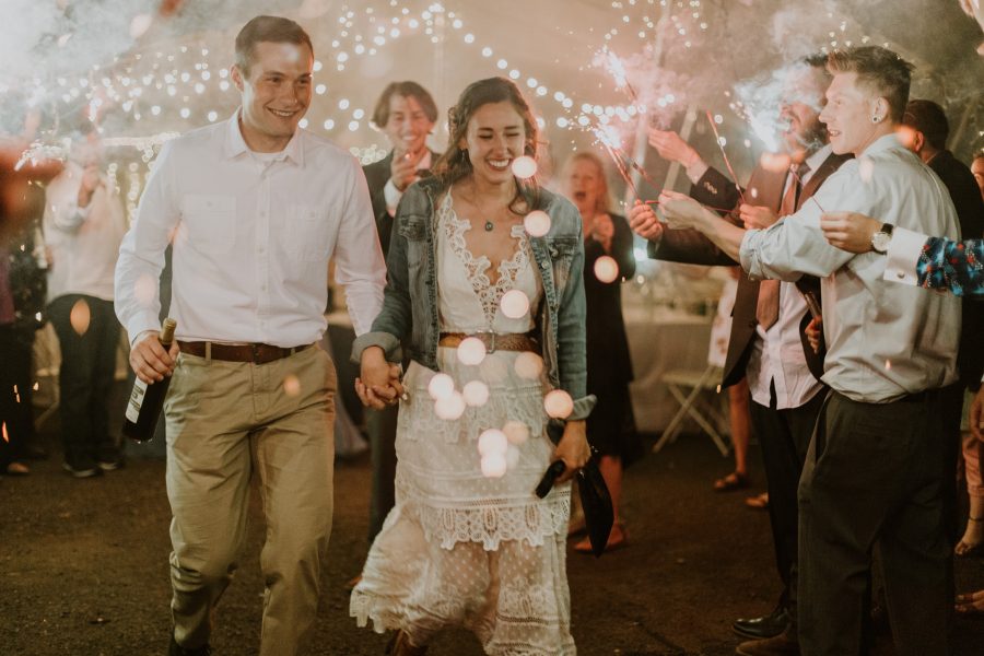couples running through a grand exit with sparklers