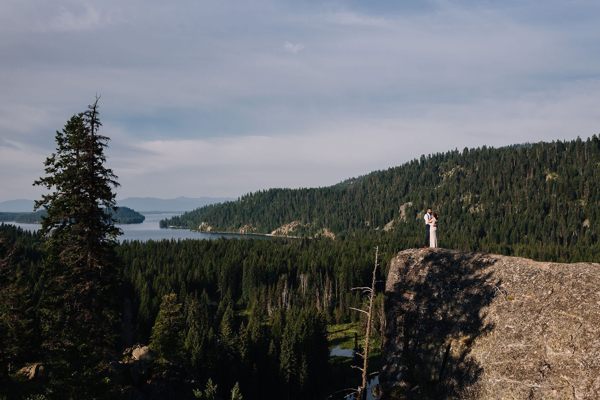 McCall Idaho elopement with a forest view and a couple standing by the edge with a lake view