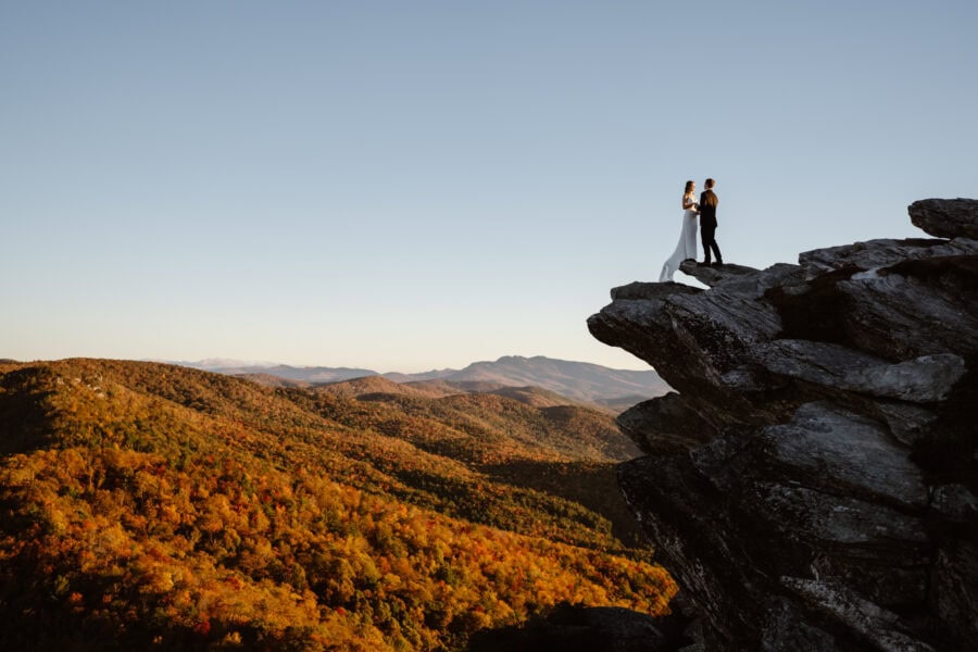 Couple standing together on a rock outcropping near Asheville, NC after their elopement