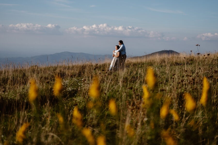 Couple standing in the Blue Ridge Mountains among wildflowers