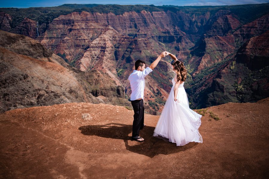 Bride and groom share a first dance on the edge of Waimea Canyon in Kauai, Hawaii