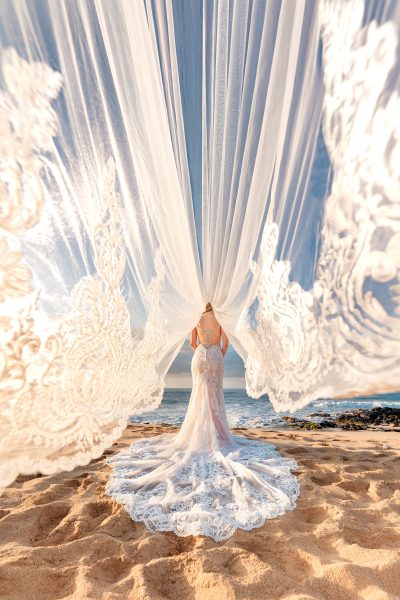 Bride with a cathedral veil blowing in the breeze in Kauai, Hawaii