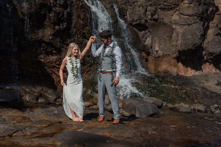 Bride and groom having their first dance under a waterfall in Kauai, Hawaii