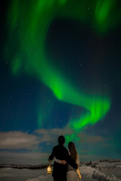 Bride and groom under a spectacular Aurora borealis in Norway on the day of their elopement