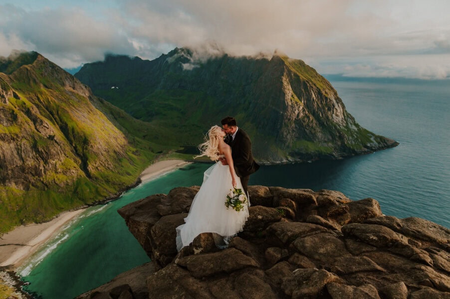 Bride and groom on an epic cliff in Lofoten islands in Norway