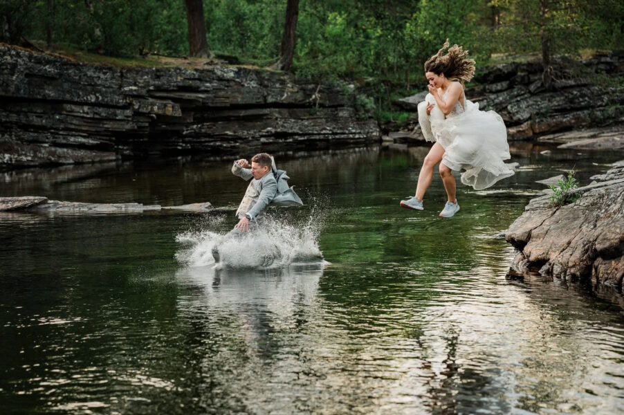 Bride and groom jumping in a river in Northern Norway on the day of their elopement