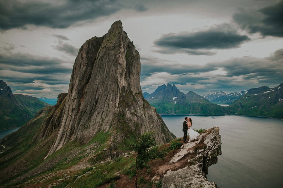 Bridal couple on the edge of a spectacular cliff in the mountains of Senja Norway