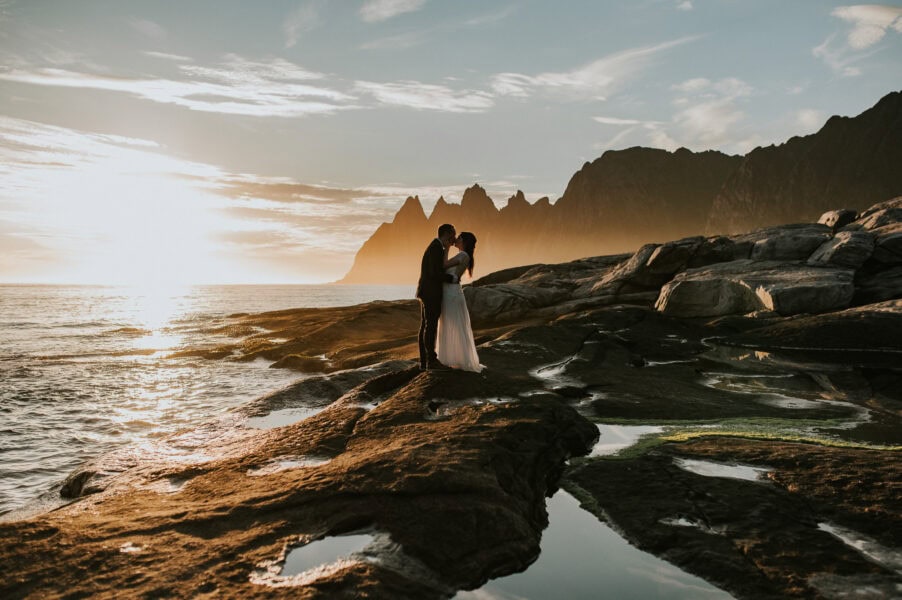 Bride and groom kissing under the midnight sun in Senja Norway