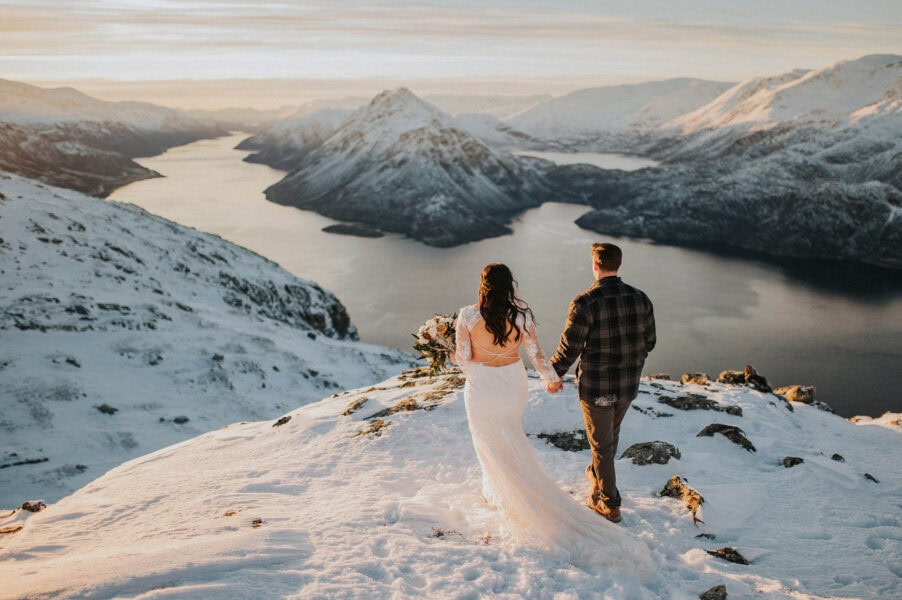 Bride and groom walking in the winter mountains of Alta in Norway