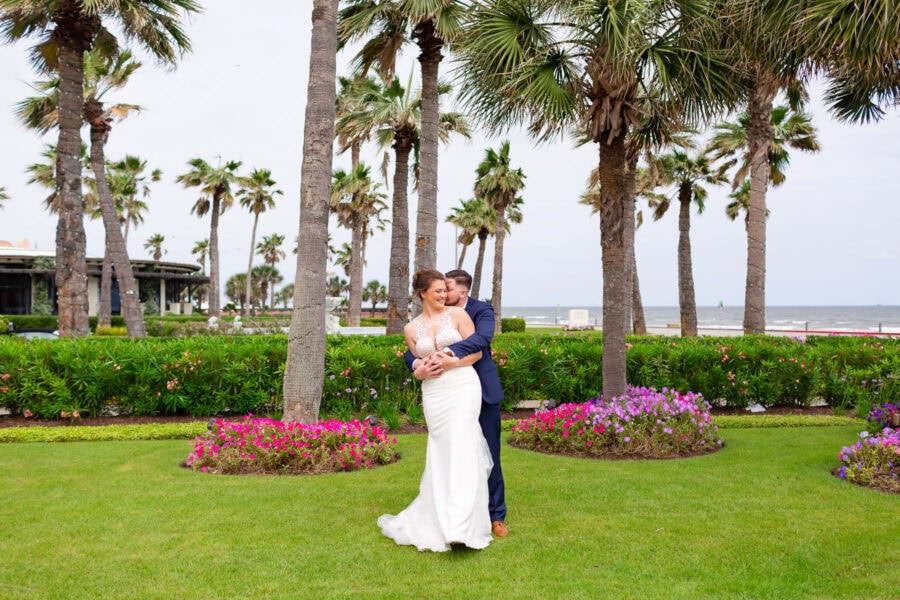 A groom hugs his bride on the lawn of the Grand Galvez hotel in Galveston Texas.