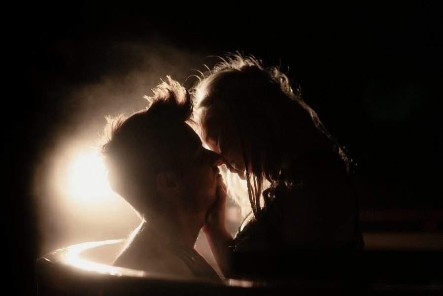 Silhouettes of a bride and groom kissing in a hot tub