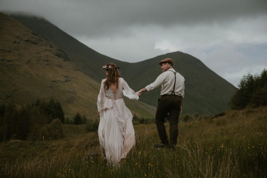 Bride and groom walking in the green hills on the Isle of Mull in Scotland