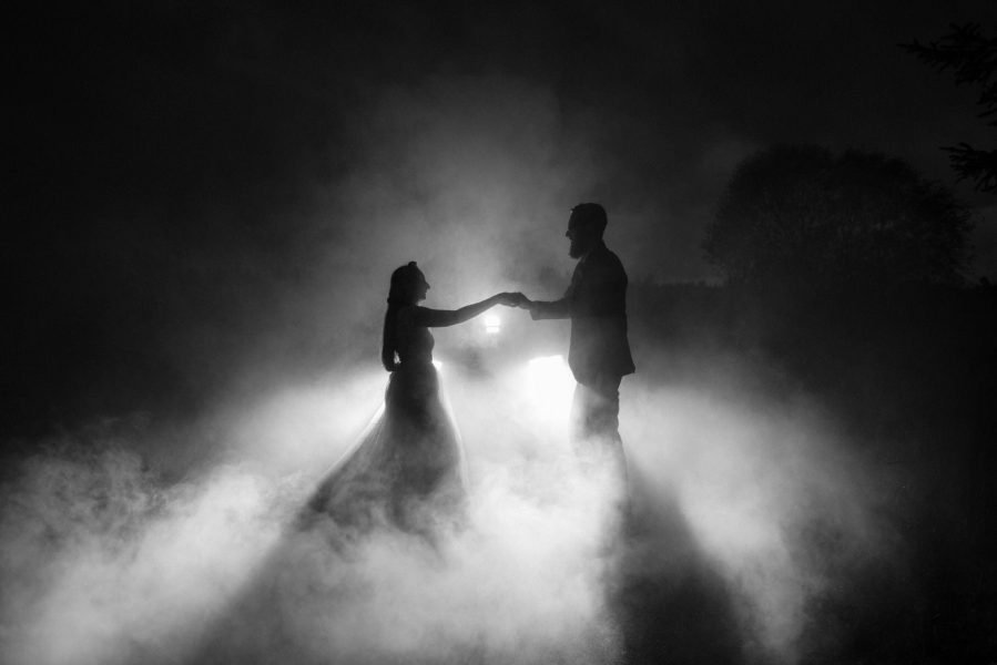 Silhouettes of a bride and groom dancing in the dark