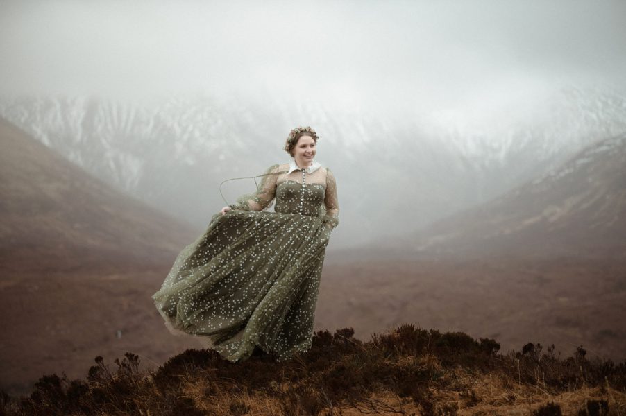 Bride in a green dress against a mountain backdrop on the Isle of Skye in Scotland