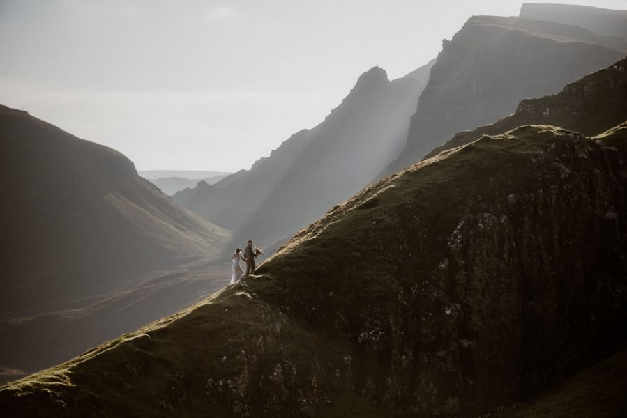 Bride and groom climbing a mountain during their Isle of Skye elopement