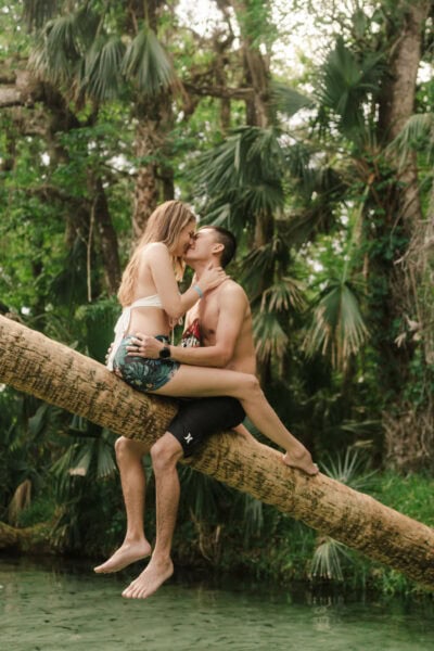 couple sits on palm tree in Florida spring