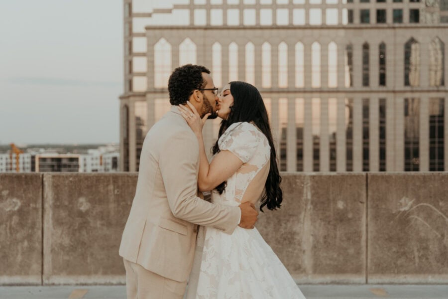 couple kisses on rooftop during their elopement