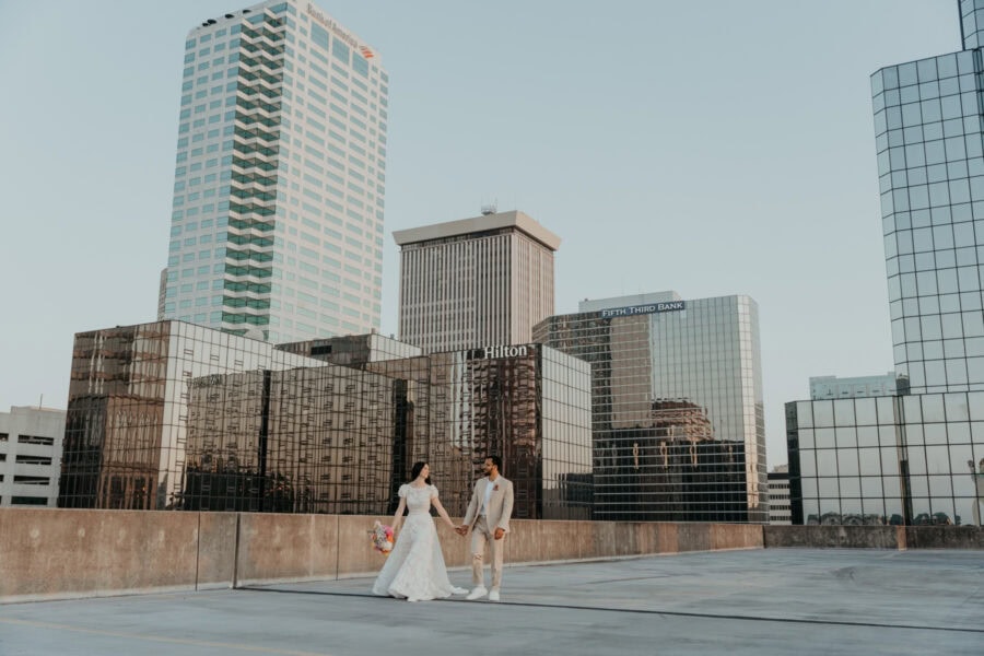 bride and groom walk on a rooftop together