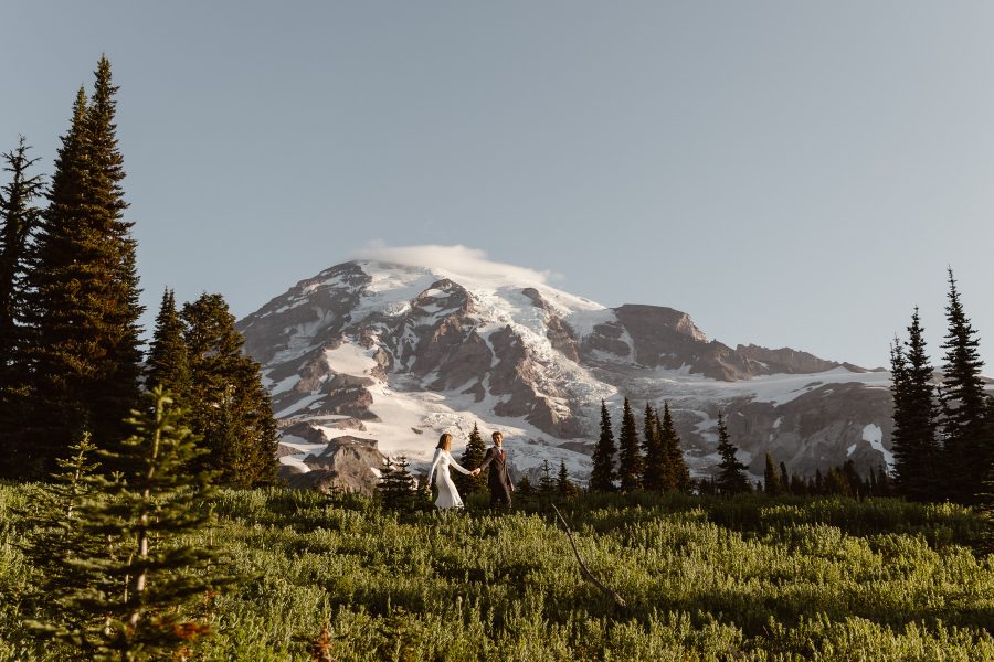 couple-walking-trails-on-mount-rainier-during-their-sunrise-elopement-holding-hands