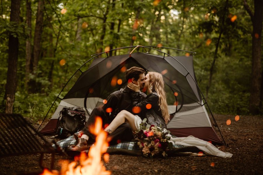 A couple kissing by a bonfire on their wedding day.