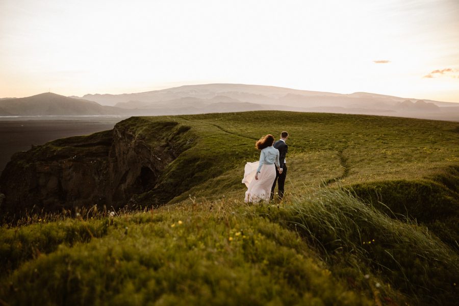 An adventurous couple exploring Iceland in their wedding attire at sunset.