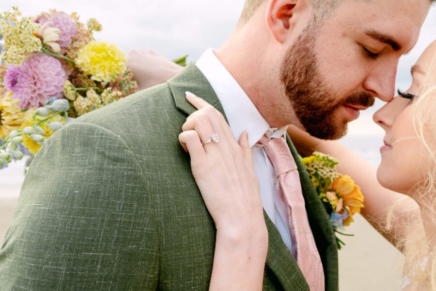 Romantic wedding couple embracing on the sandy shores of Cannon Beach.