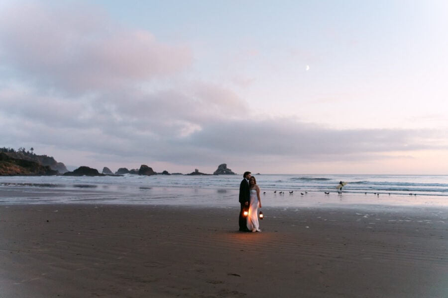 Romantic couple at Indian Beach at night, surrounded by glowing lanterns, with the sound of waves and a starlit sky creating a magical atmosphere