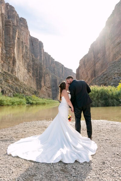 Bride and groom embracing during their Big Bend National Park elopement at Santa Elena Canyon, surrounded by towering canyon walls and the Rio Grande.