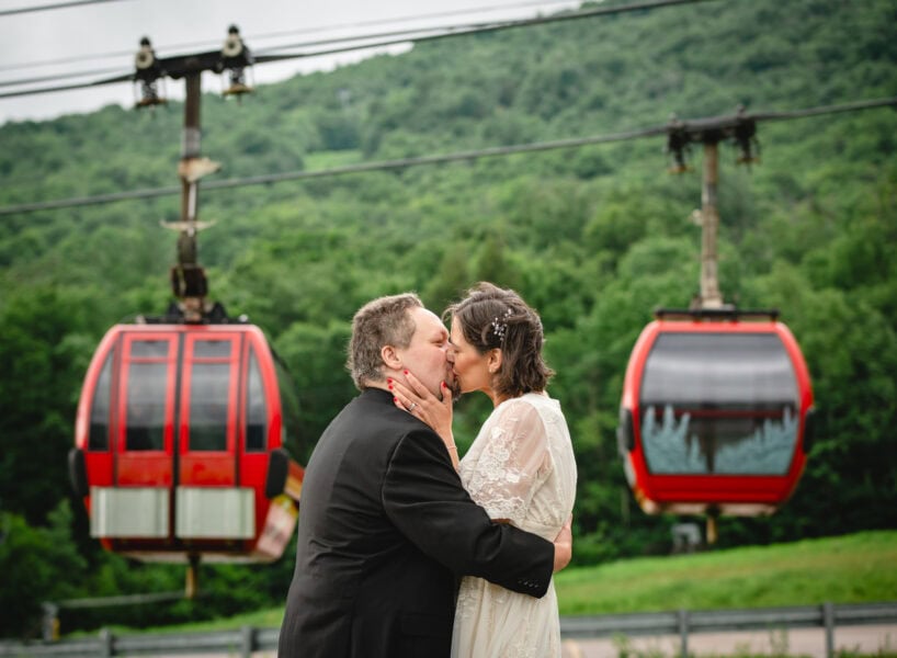 elopement couple kissing in front of the Stowe gondola in Vermont