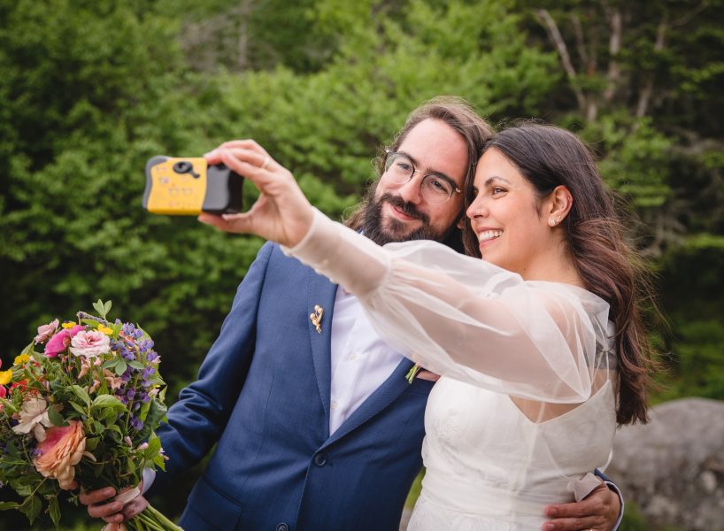 bride and groom taking selfie with disposable camera for their Vermont elopement