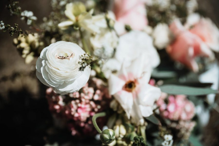 light and moody bouquet with rose gold wedding ring
