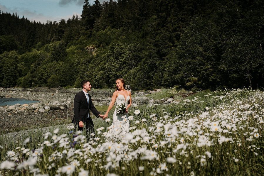 Alaska bride and groom in daisy field
